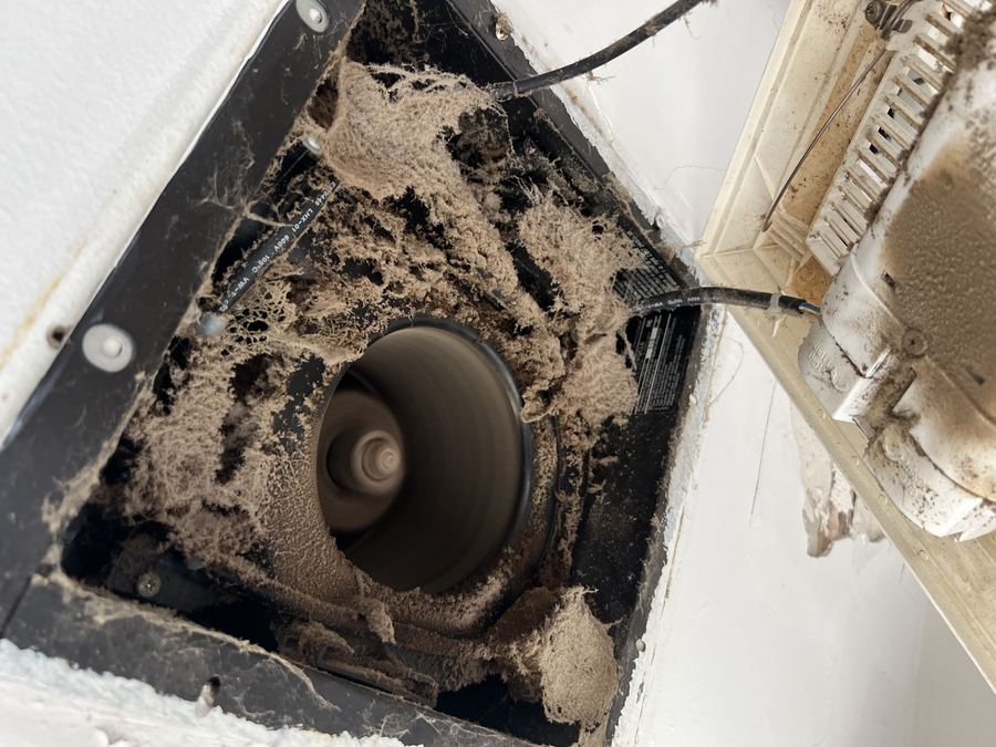 Dusty bathroom exhaust fan before cleaning